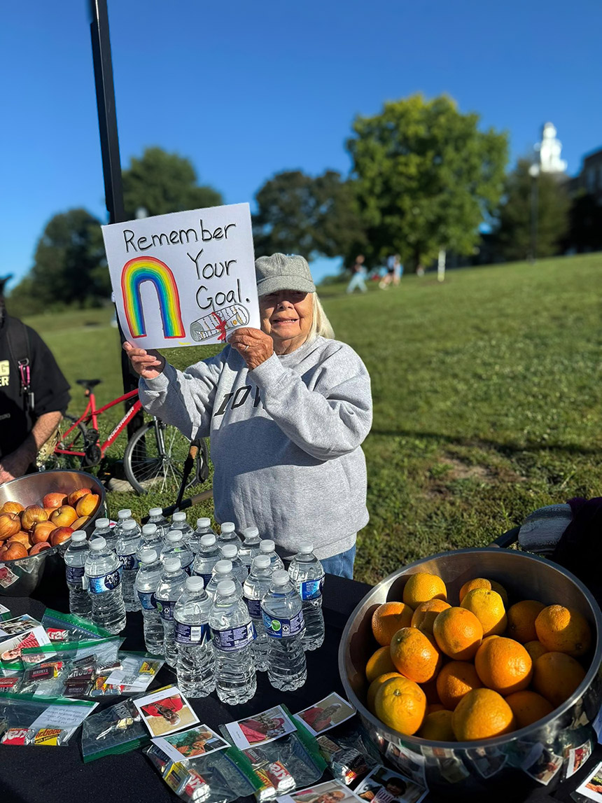 A senior woman holds up a sign that says 