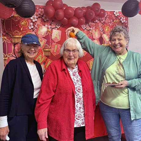 Three women celebrate during a Chinese New Year event at Walden Place Senior Living.