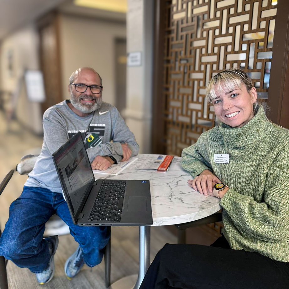 A team member and resident at Walden Place smile in a common space.