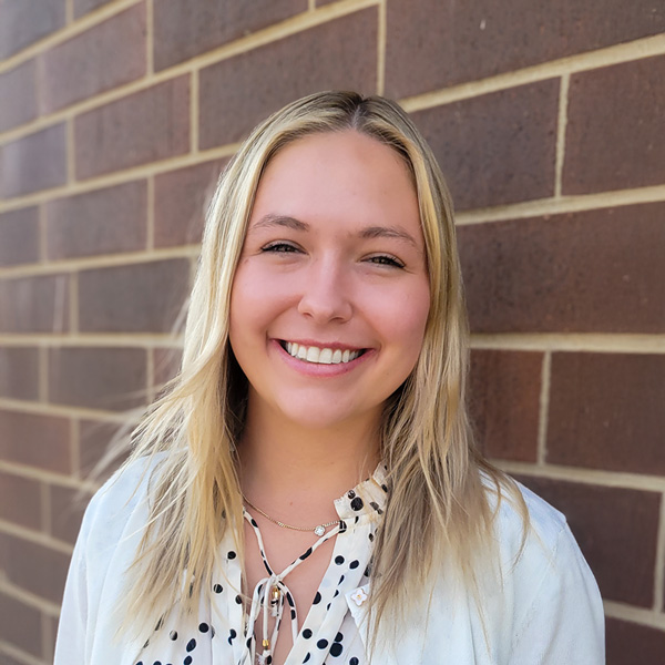 Sydney Busse, Senior Living Coordinator at Walden Place Senior Living, smiling in a professional outdoor headshot against a brick wall.